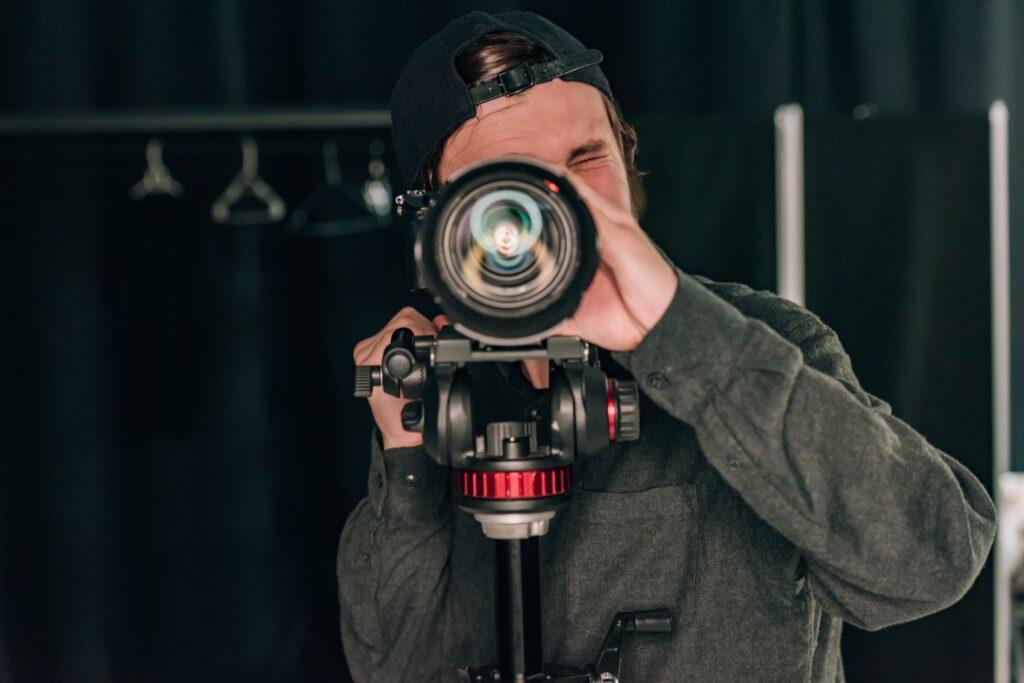 Videographer looking through camera in photo studio